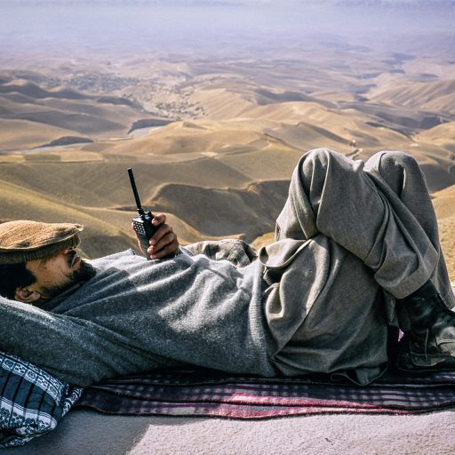 Afghanistan, 1998. Ahmad Shah Massoud above the city of Taloqan. After regaining control of the city below, he rested while waiting for the helicopter that would take him to other fronts. © Pascal Maitre.
