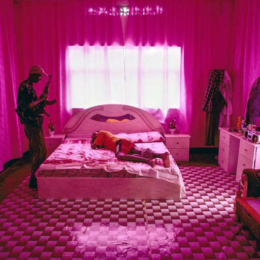 Somalia, Mogadishu. This militia leader is lying on his bed in a room decorated in pink. © Pascal Maitre.