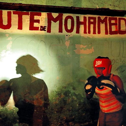 In the depths of Tata Raphael Stadium, formerly known as the 20th of May Stadium, where the famous Ali/Forman fight took place in 1974, this young female boxer trains with limited resources in the former locker room of Muhammad Ali. © Pascal Maitre.