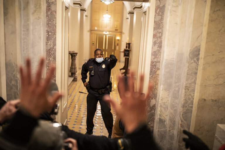 U.S. Capitol Police (USCP) Officer Eugene Goodman confronts protesters as they storm the Capitol in Washington, D.C., after listening to a speech by President Trump on January 6, 2021. A large mob convened in Washington, D.C., for a "Save America" or "Stop the Steal" rally incited by President Trump and stormed the United States Capitol building, fighting with police and damaging offices and rooms as they made their way through the building. As President Trump openly condoned the violence, the D.C mayor called for a 6 PM curfew and mobilized the National Guard. © Ashley Gilbertson / VII.