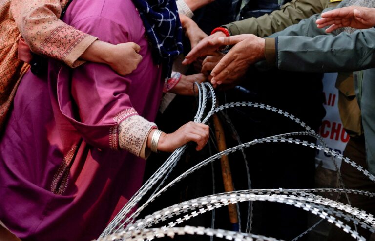 A woman demands that Indian security forces release the body of her brother, Muhammad Shafi Parry, who was killed in an explosion at a police station in Srinagar, Indian Kashmir, on Nov. 15. Sharafat Ali/Reuters.