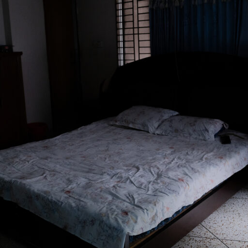 “You see this carefully decorated home—he did it all. I cannot leave this love behind. I cannot go anywhere, step out for a while, cannot leave the children behind, by themselves. I only wait, what if he’s back and I’m not here? In Old Dhaka, you know what guardians do—if a woman’s husband dies or goes away, they arrange her remarriage. I tell them: if Jahir comes back, will you be able to tell him you married me off? If he can see and accept that, and you can answer him, then I will marry—no problem. My elder brother says, can a person live like this? I say, why not? What is the problem? Nine years have passed for others, but for me, life stopped in 2013.”
— Reshma Akter,wife of Chanchal who was abducted on 2 December, 2013. The photograph was taken on June 5, 2025, Dhaka. © Mosfiqur Rahman Johan.