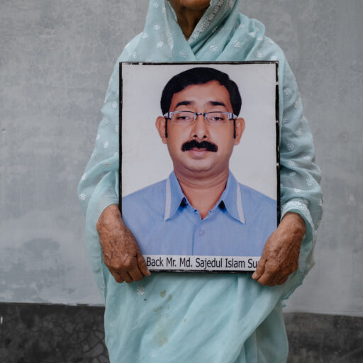 Hazera Khatun, founder of Maayer Daak, holds a photograph of her missing son, Sajedul Islam Sumon, in this image taken on February 12, 2025. Sumon, a leader of the Bangladesh Nationalist Party, was allegedly abducted by members of the Rapid Action Battalion in Dhaka in 2013 and has remained missing since. © Mosfiqur Rahman Johan.