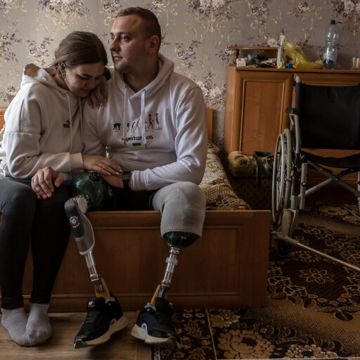 Serhiy Kopyschyk, 25, and Svitlana Kopyschyk, 25, pose for a portrait in Pokashchiv village, Volyn region, Ukraine on October 3, 2023. Svitlana and Serhiy got married in January this year and their son Marko was born in August. He joined the army the day after the invasion and he suffered severe injuries on July 27, 2022 in Kherson region, which resulted in him losing both legs, one above the knee, and eyesight in one eye. They live with Svitlana's parents and dream to buy their own house. © Oksana Parafeniuk.