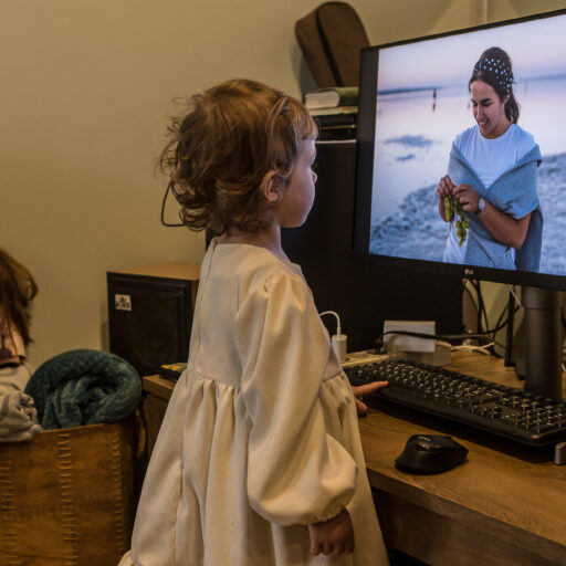Lizi Haidarzhy, 2, looks at the photo of her mother Anna Haidarzhy, who was killed in the Russian drone strike earlier this month together with her 4-month-old son Tymofii, Lizi's brother on Monday, March 18, 2024 in Odesa, Ukraine. Weeks following the tragedy, little Lizi and her father Serhii lived with Anna's parents and three sisters in their family home. As a result of a Russian drone attack on March 2, part of a residential building collapsed. After two days of searching operations, rescuers retrieved the bodies of 12 dead from under the rubble, including five children. © Oksana Parafeniuk.