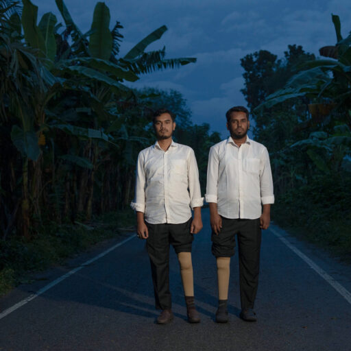Ruhul Amin and Ishrafil are survivors of police kneecapping in Bangladesh. On August 3, 2016, they were arrested; the following day, they were taken to a secluded place and shot in their knees.“After they shot me, I had to have one of my legs amputated. Since then, I rarely leave home. I feel uncomfortable going outside, even visiting relatives. My family tried to arrange my marriage, but I feel ashamed—I have no source of income anymore.”Bangladesh — October 29, 2025. © Mosfiqur Rahman Johan.