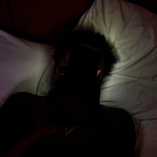 Wixom, Michigan — Ousmane Fall rests on his bed after a shift at a franchise restaurant in downtown Detroit on Monday, November 24, 2025. After receiving his Employment Authorization Document while living in a shelter in Brooklyn, New York and selling goods on the street, Fall moved to Michigan to join his brother and now works long hours at a franchise restaurant to send money home to Senegal and help pay for his sister’s education. © Arisa Haboshi.