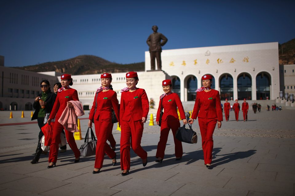 An all girls group of Young Communist League members walks past a statue of Chairman Mao Zedong in front of the Yan'an Revolutionary Memorial Hall in Yan'an, China on Nov. 7, 2009. Yan'an is promoted as the "Revolutionary Holy Land" and offers a number of museums, monuments and other "Red Tourism" sites supported by the Chinese government.