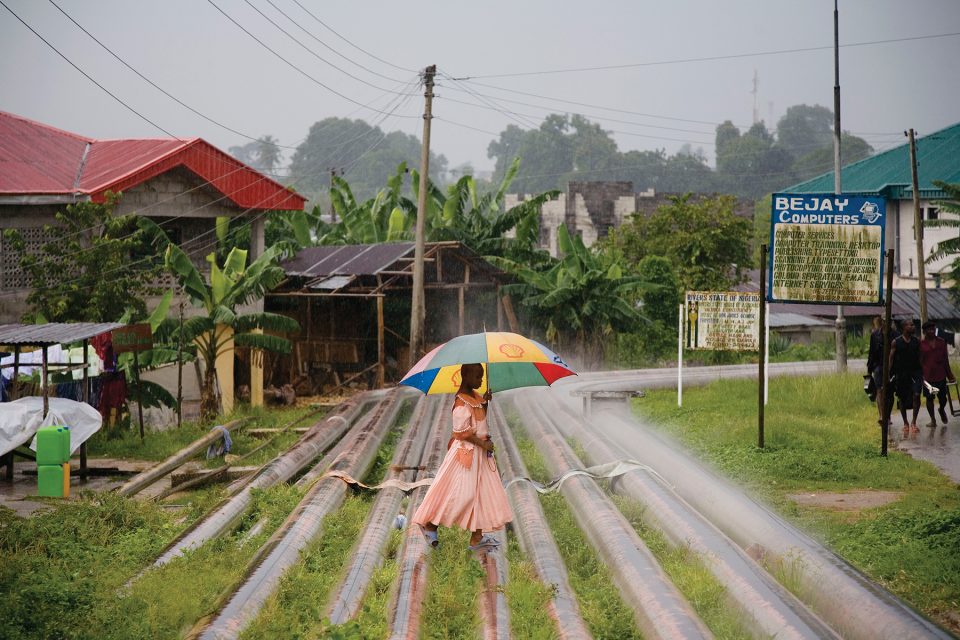 Oil pipelines create a walkway for this young woman through the village of Okrika, in the Rivers state, Nigeria on June 24, 2006.